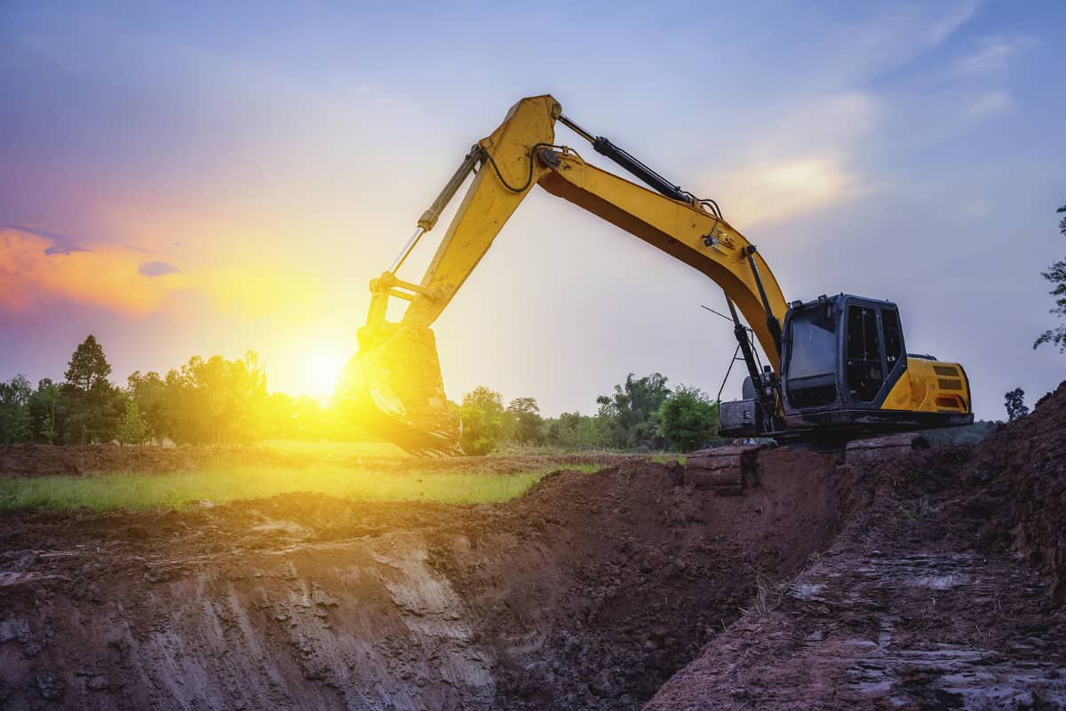 A beautiful image taken during sunset of a bobcat excavator while excavating an open field
